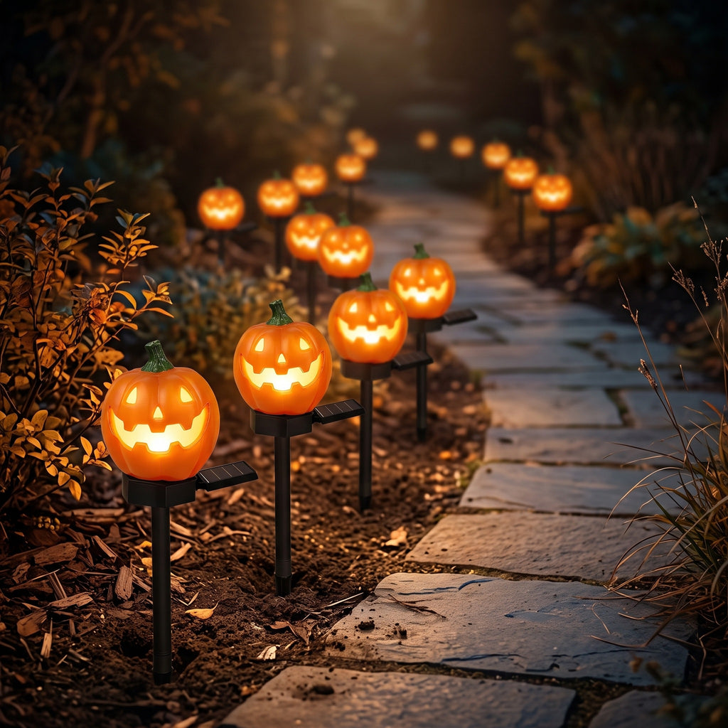 Solar pumpkin pathway lights glowing along a garden path at night